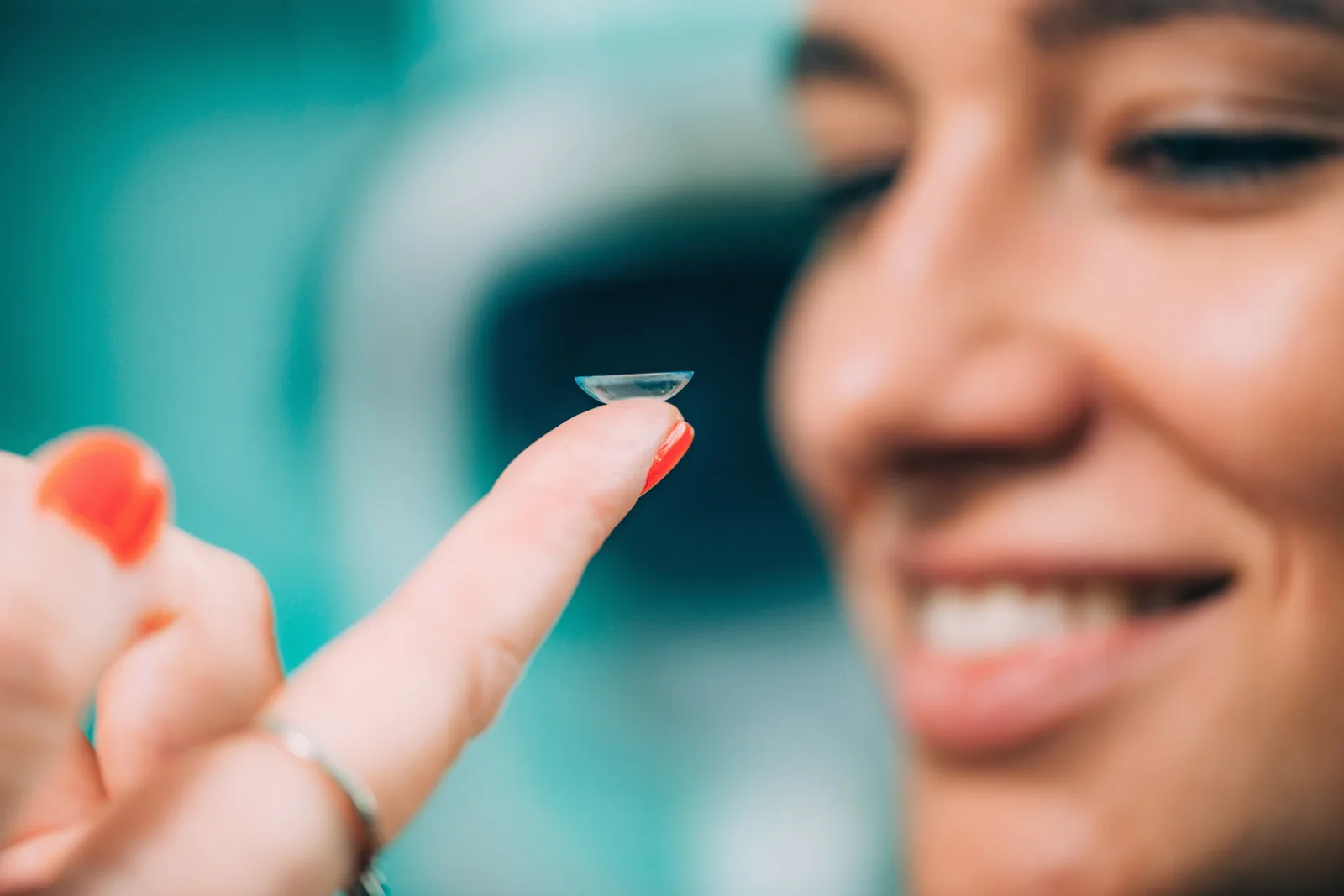 Woman holding a contact lens on her fingertip