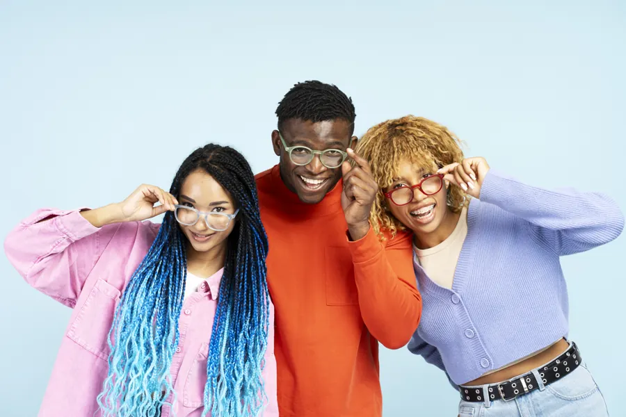 Three friends smiling in colourful glasses